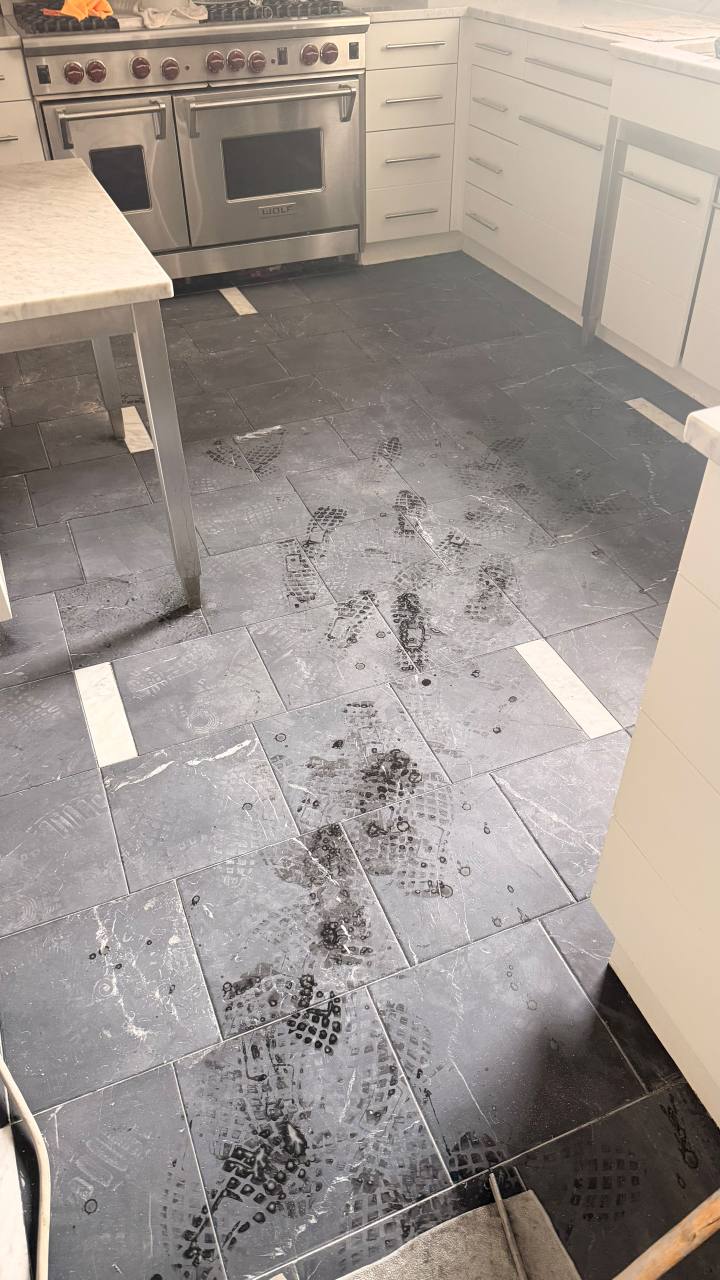 Dull and scratched Nero Marquina black marble kitchen floor before restoration