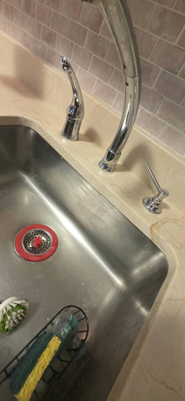 Repaired Crema Marfil marble edge around a stainless-steel sink