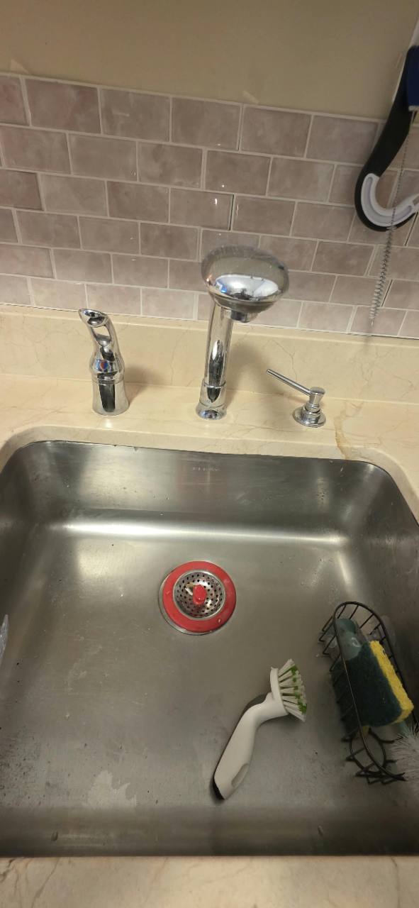 Repaired Crema Marfil marble countertop surrounding a stainless-steel sink