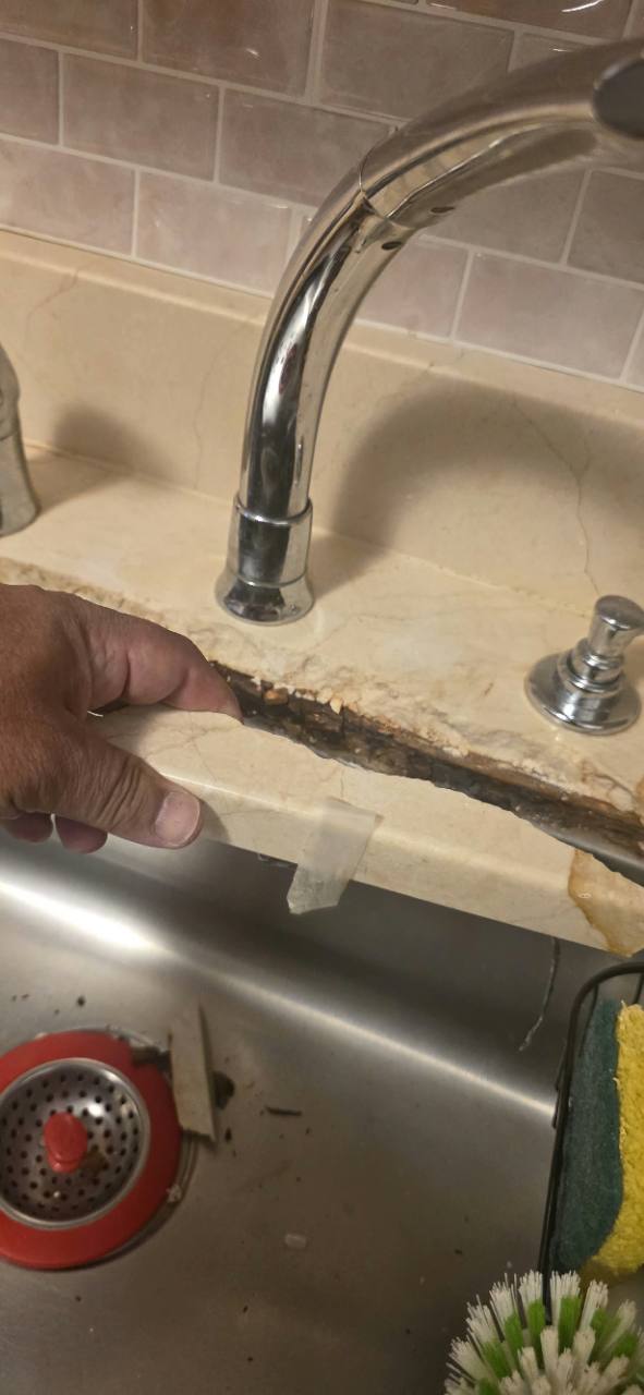 Detached piece from a broken Crema Marfil marble sink edge