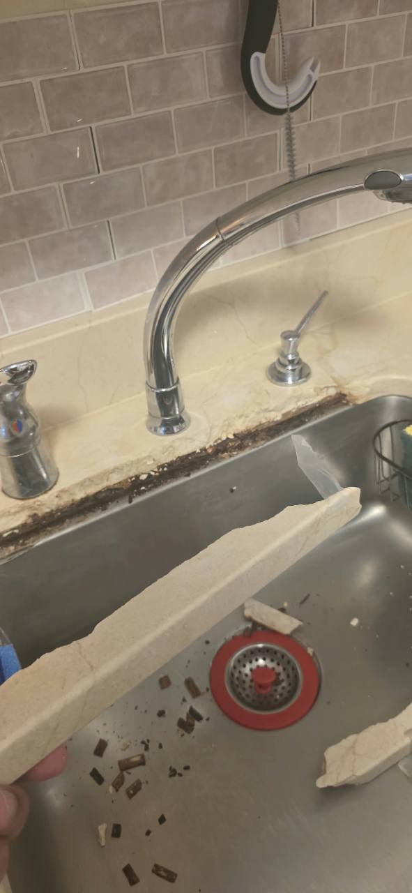 Broken Crema Marfil marble pieces saved inside a kitchen sink